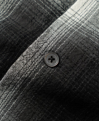 Close-up of button on black-and-white ombre check sports shirt placket
