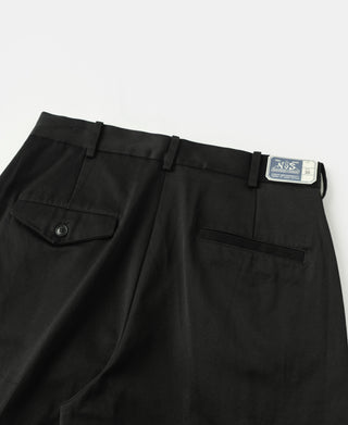 Black cotton twill trousers with pleats, pocket flap, and size label