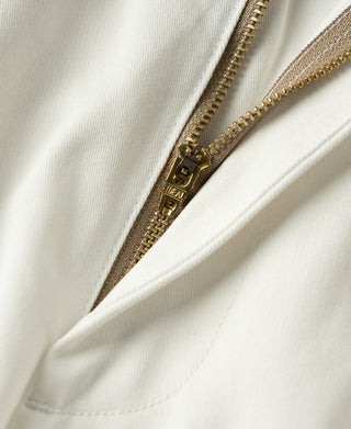 White trouser fly with brass zipper, inside pocket seam, and top stitch.