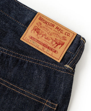 Denim jeans back yoke with leather brand patch and orange stitching