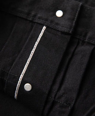Black denim jacket front placket with snap closures and contrast stitching