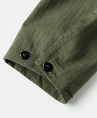 Olive utility jacket hem area with two black buttons and stitched placket