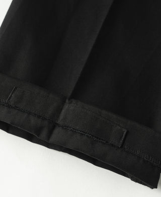 Black cotton twill trouser hem with visible stitching and cuff-like finish