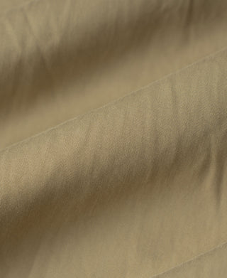 Olive bomber jacket fabric close-up with subtle woven texture