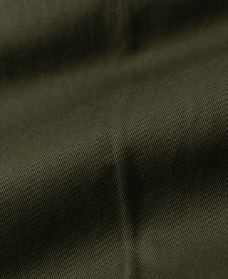 Olive cotton twill trousers fabric close-up with subtle woven texture
