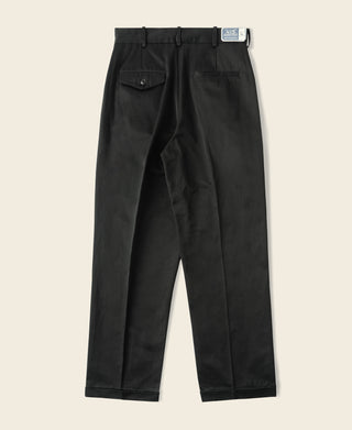 Black cotton twill trousers showing pleats, waistband, and front pockets