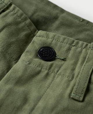 Olive fatigue trousers pocket flap with dark button and herringbone texture
