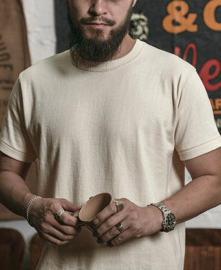 Apricot athletic T-shirt with crew neck, worn by a man adjusting his sleeves