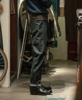 Prewashed selvedge denim jeans, dark indigo with visible selvedge cuff and stitched hem