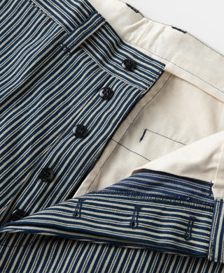 Striped work pants showing button fly and cream interior waistband.