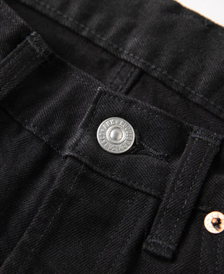 Black denim jeans close-up: waist label patch and button placket