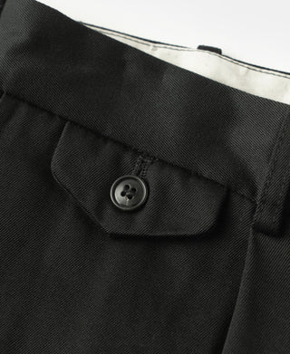 Black trouser front close-up with buttoned pocket flap