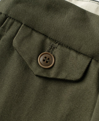 Olive pocket flap with round button and curved seam on cotton twill trousers