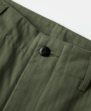 Olive button waistband close-up with fabric placket and belt loop detail.