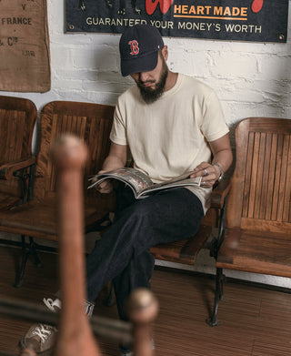 Apricot athletic T-shirt with crew neck worn while seated and reading a book