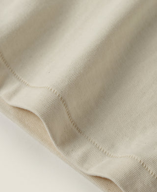 Apricot athletic T-shirt fabric close-up with visible stitching and knit texture