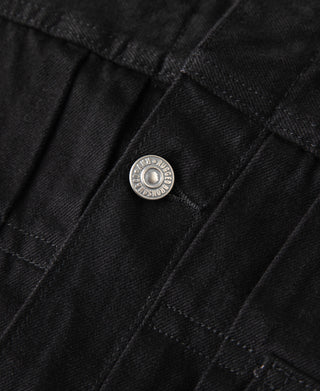 Black denim jacket close-up of round metal snap button on flap