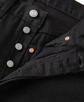 Black denim jeans close-up: waistband hardware and stitched pocket opening