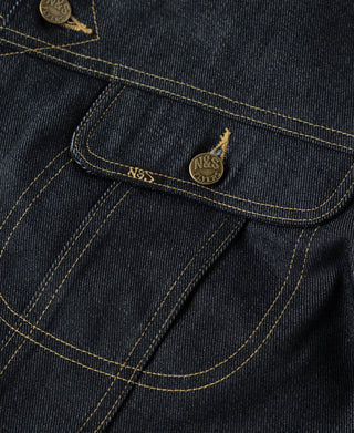 Indigo denim jacket chest yoke close-up with embroidered logo and coin-style buttons