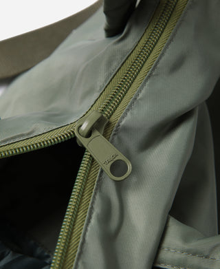 Olive helmet bag with side zipper pull and green braided zipper trim