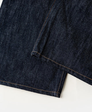 Hem view of indigo selvedge denim jeans with orange stitch seam