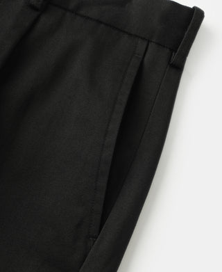Black cotton twill trouser leg with subtle pleat seam and crease