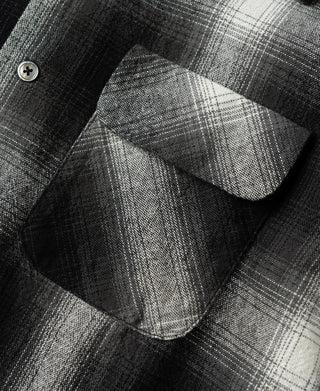 Close-up of flap pocket on black-and-white ombre check sports shirt