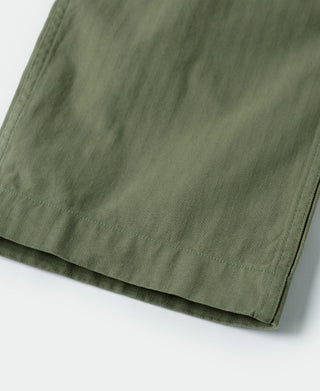 Olive fatigue trousers hem with seam stitching, close-up
