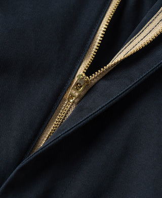 Navy trousers with gold-tone zipper detail on inner pocket
