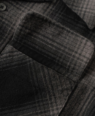 Chest pocket on black and gray ombre check sports shirt, close-up of fabric and stitching
