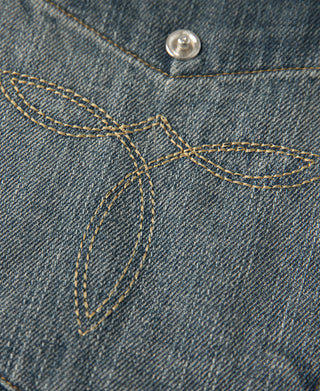 Blue slub denim western shirt pocket flap with decorative topstitching and snap