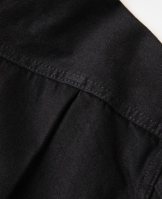 Black denim jacket sleeve cuff and fabric seam detail