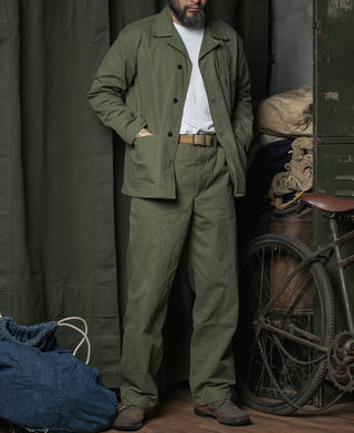 Olive utility pants with straight legs and ankle cuffs, worn with belt