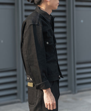 Black denim jacket side view with chest pocket and snap button collar